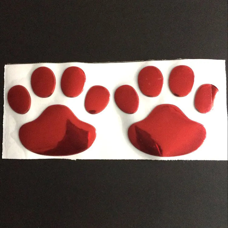 Pair of hand-shaped brush stroke car stickers with dog footprint details on a vehicle bumper.