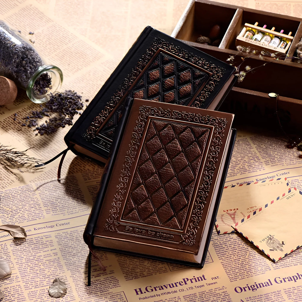 A5 hardback notebook with embossed faux leather cover in bronze colour, shown open on a table.