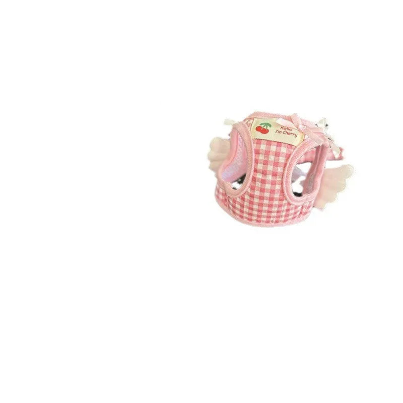 Small dog wearing pink cotton chest and back harness with hand holding rope attachment
