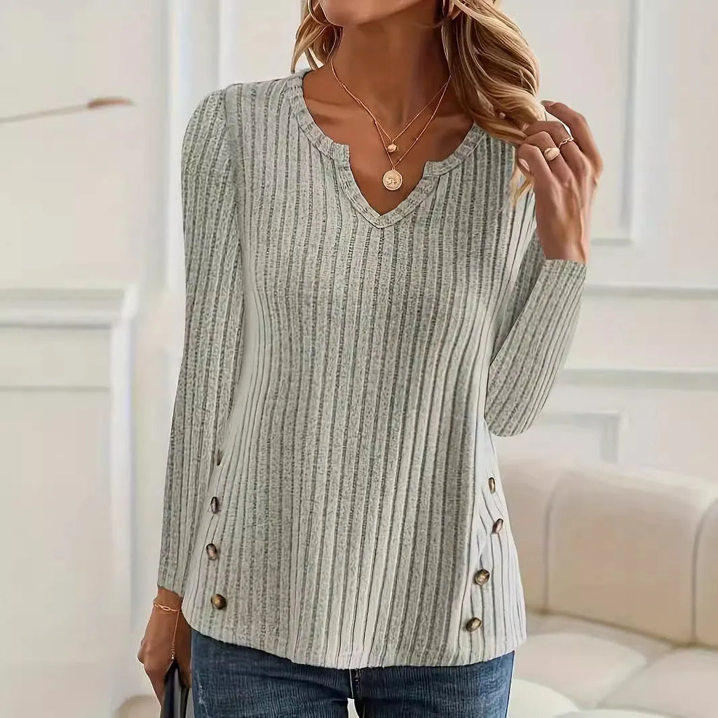Simple solid colour knitted button sweater on hanger showing regular sleeves and button details
