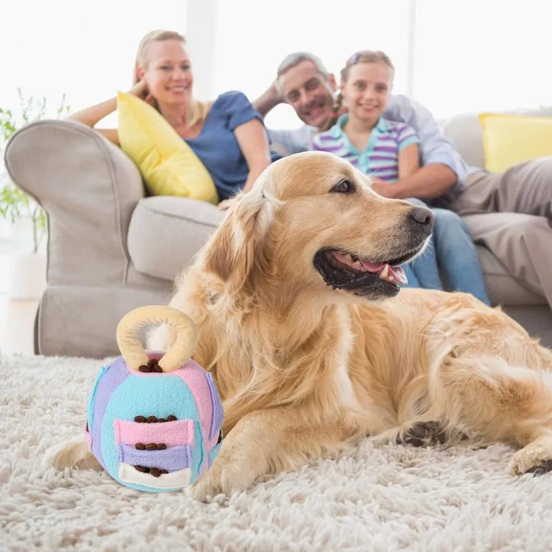 Green or pink polyester plush squeaky ball dog toy with treat pockets, shown next to a dog treat for scale.