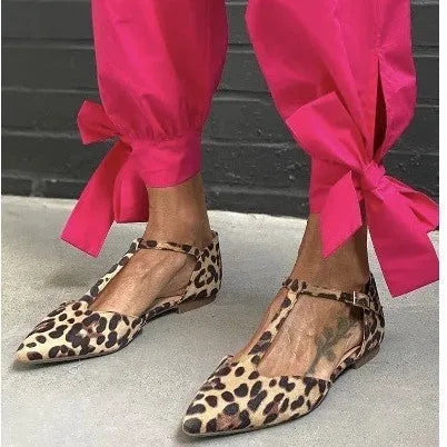 Leopard print women's pumps with pointed toe, chunky low heel, and cross shoulder straps.