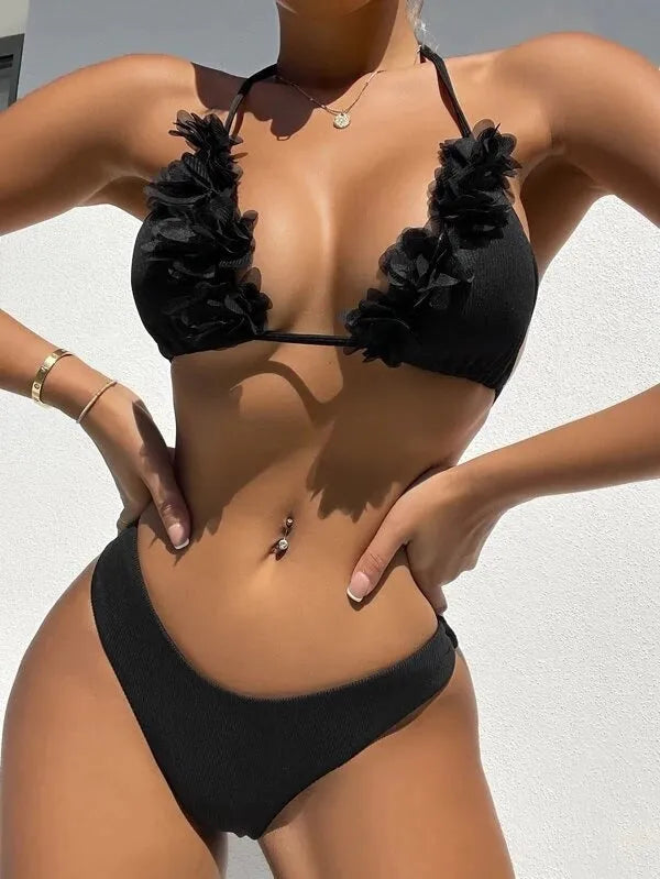 Black women's bikini set with gathered top and matching shorts laid flat.
