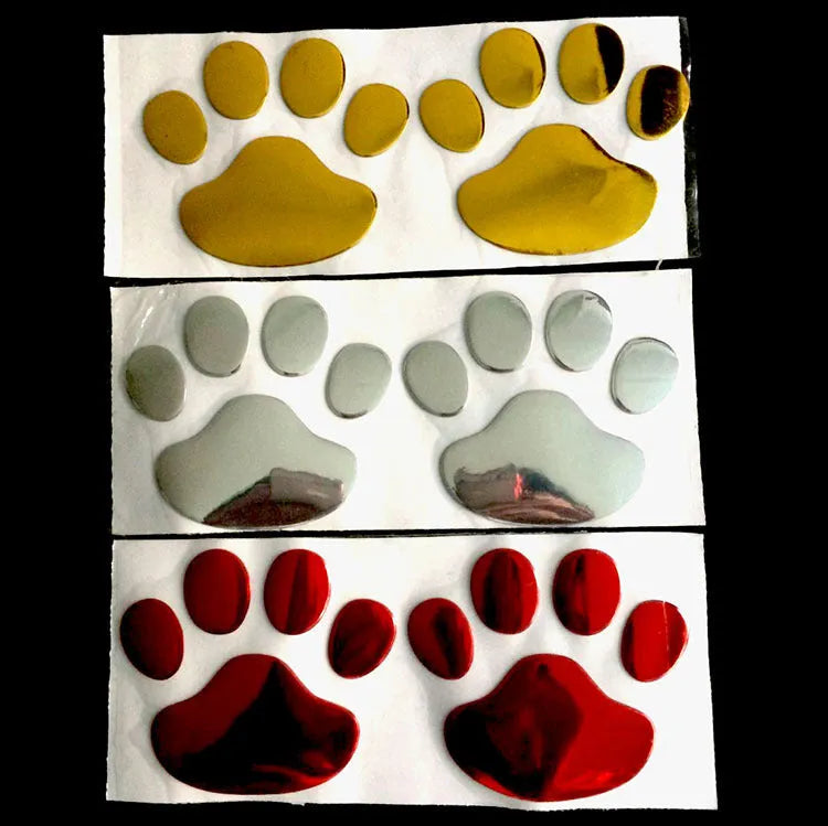 Pair of hand-shaped brush stroke car stickers with dog footprint details on a vehicle bumper.