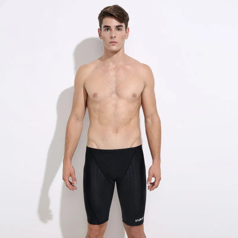 Men's black polyester swimming trunks set with anti-fog goggles, waterproof cap, ear plugs, nose clip, and carry bag.