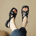 Women's black patent leather square toe beach sandals with cross-band strap on a low rubber sole.