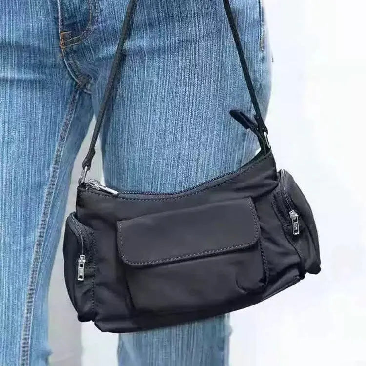 Black nylon shoulder bag with double pockets and side line detail, showing compact dimensions
