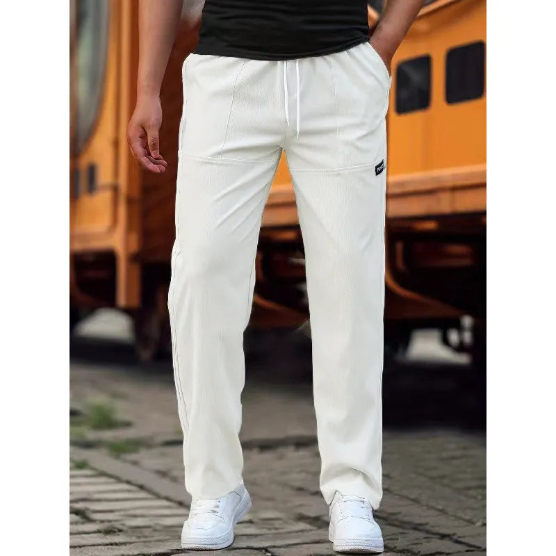 Men's polyester trousers in light grey colour, shown folded, for spring and autumn wear.