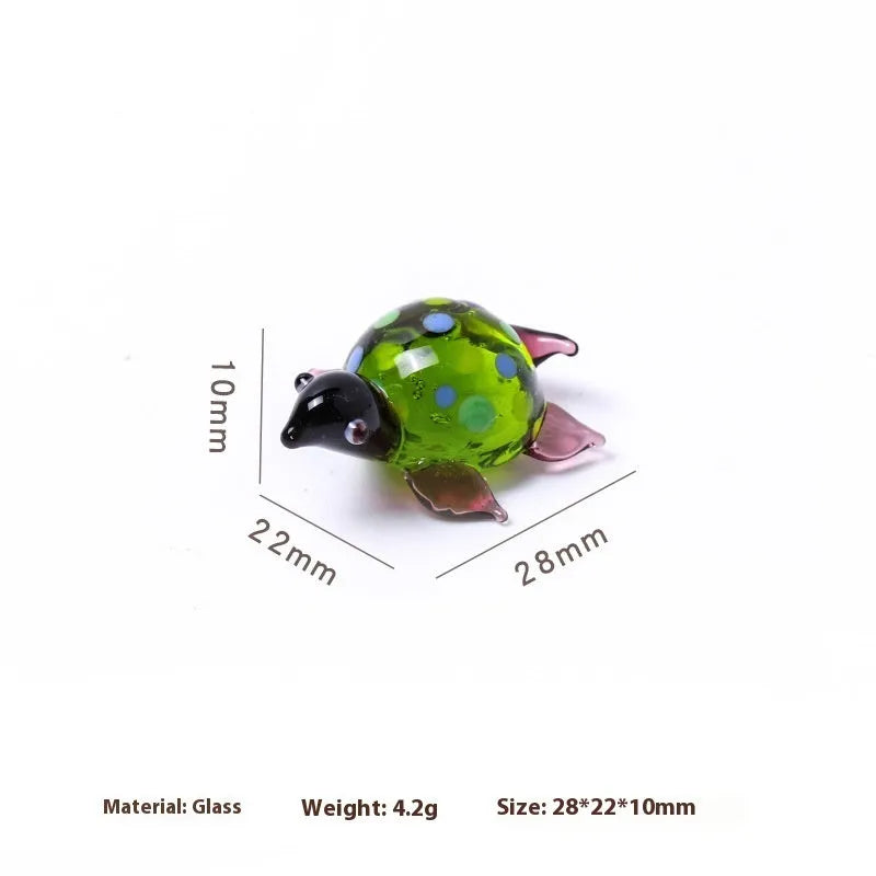 Glass geometric turtle ornament in blue head with blue shell colour variation on wooden desktop
