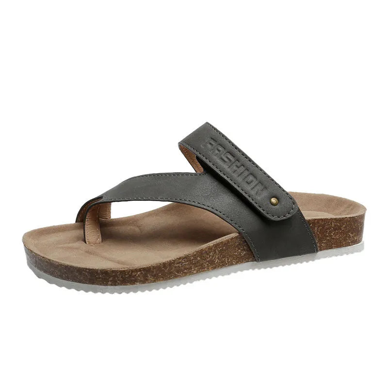 Flat toe ring flip-flops in blue with a thick foam sole on a wooden floor.