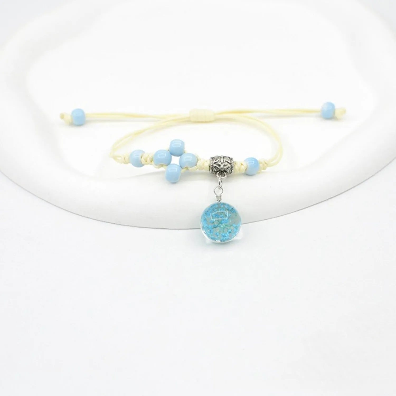 Women's hand-woven glass bracelet with large 1.4cm beads containing dried flowers, shown in blue colour option