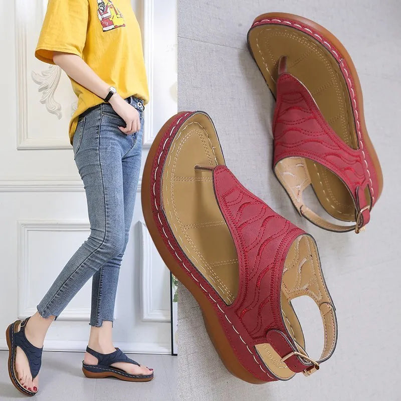 Women's black wedge heel sandals with an adjustable back strap buckle on a white background.