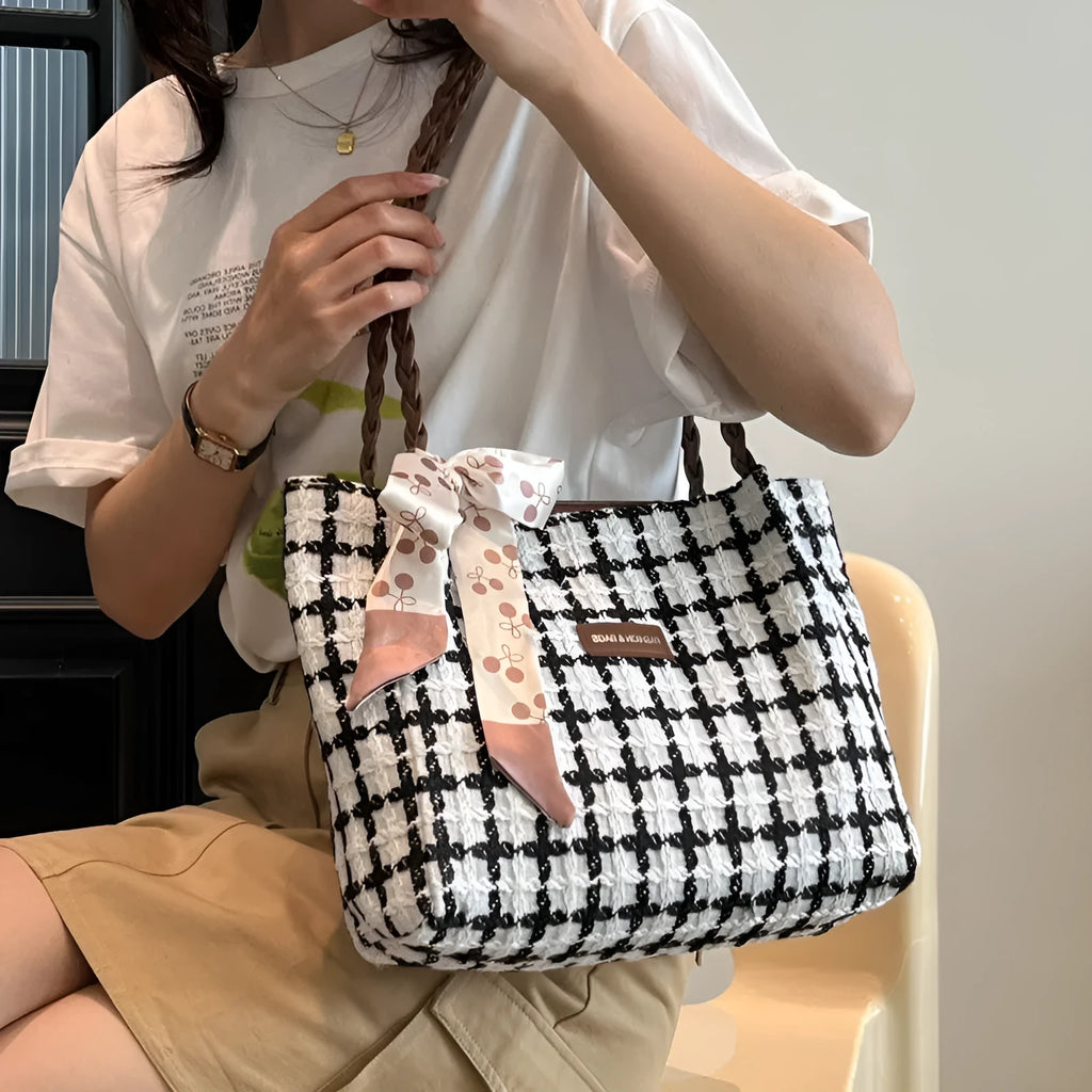 Black woven wool shoulder bag showing horizontal square shape and external pocket.
