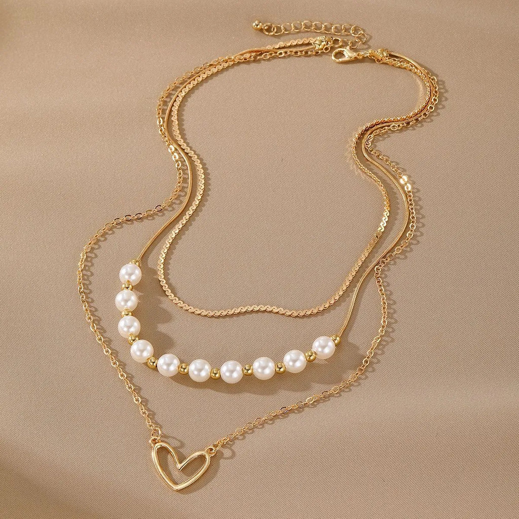 Vintage gold necklace with double heart pendant on textured pearl chain