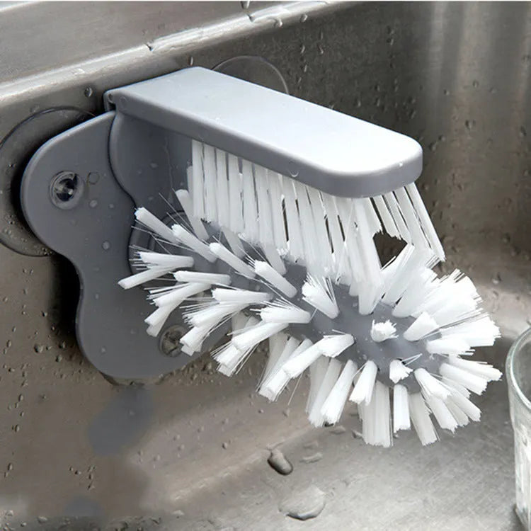 Grey 2 in 1 cup scrubber with double-sided bristles and three suction cups on the base for cleaning glassware.