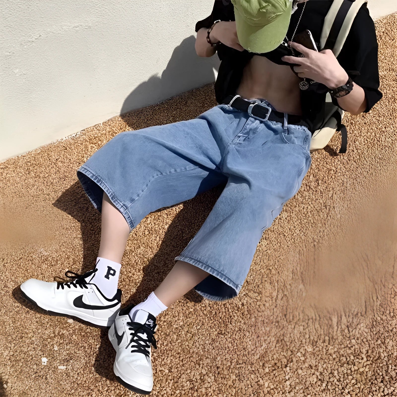 Man wearing blue washed denim pirate shorts with a cropped length and high waist.