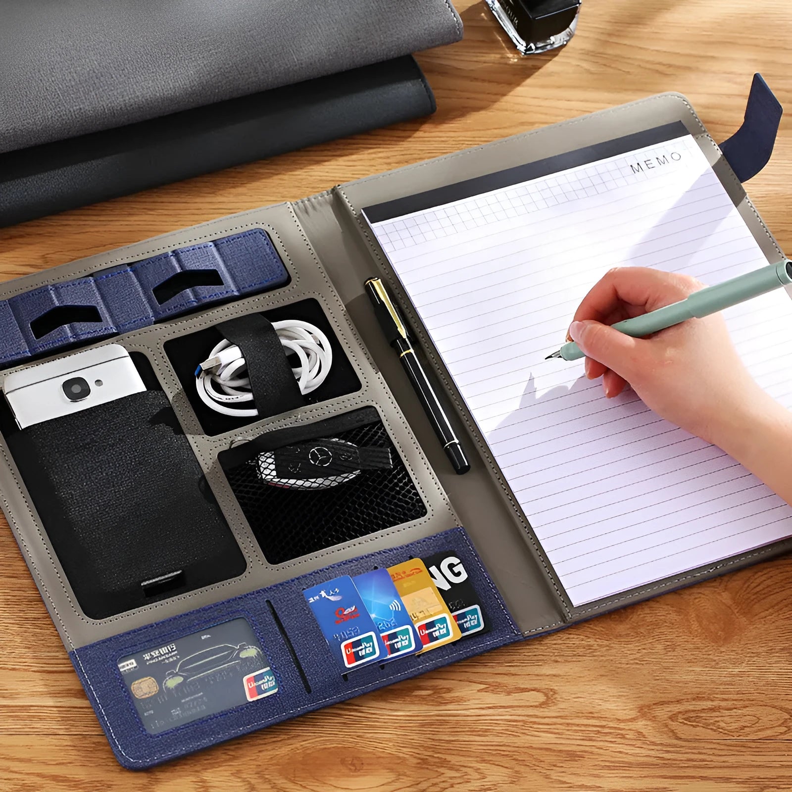 Black leather A4 business folder holding documents, with a notepad and pen inserted