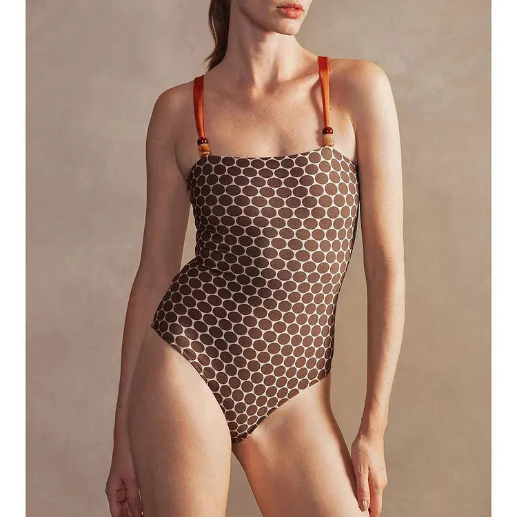 Women's printed dot pattern one-piece swimsuit with matching wrap skirt set on a mannequin
