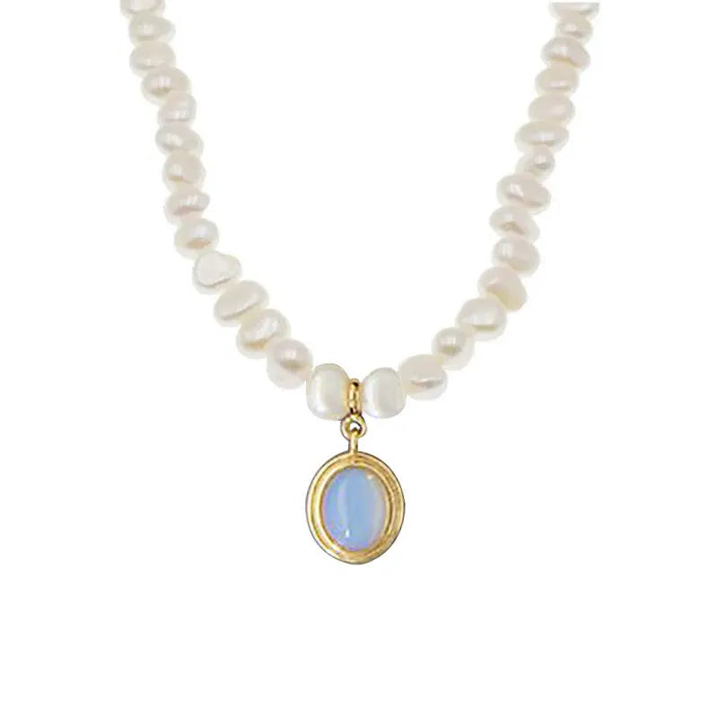 Geometric sterling silver necklace with irregular pearl pendant on a silver chain.
