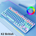 Compact mechanical gaming keyboard with RGB lighting next to laptop