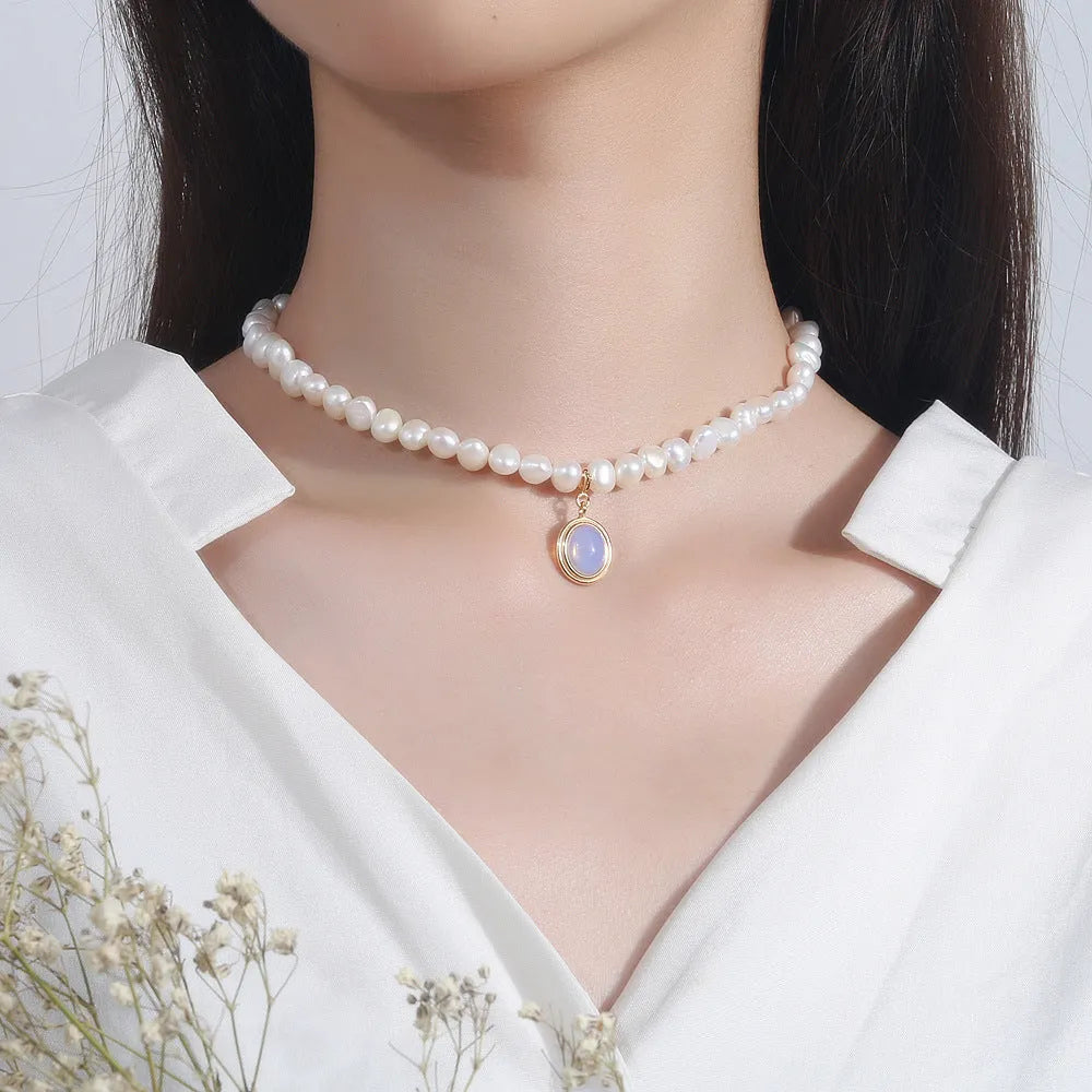 Geometric sterling silver necklace with irregular pearl pendant on a silver chain.