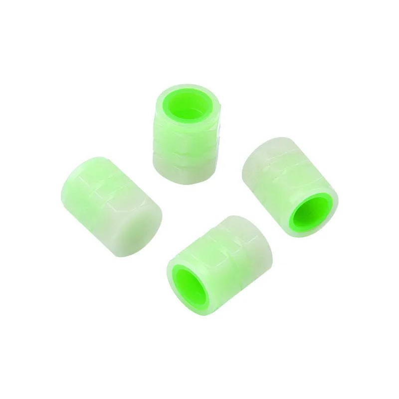 Pack of four black rubber car valve caps with luminous glow-in-the-dark tops.