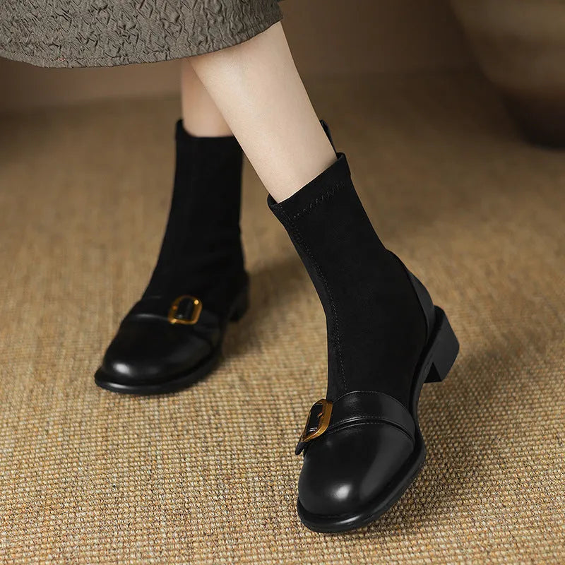 Women's black low heel Martin ankle boots with lace-up front and buckle stitch detail on a white background.