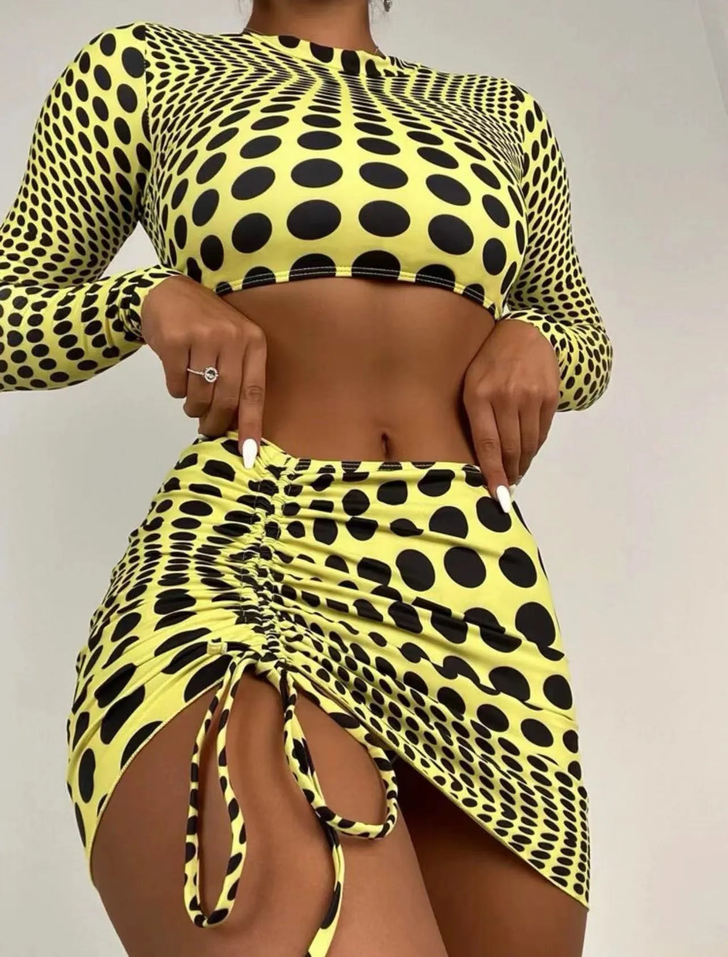 Women's green and yellow polka dot three-piece swimsuit set with top, skirt, and bra.