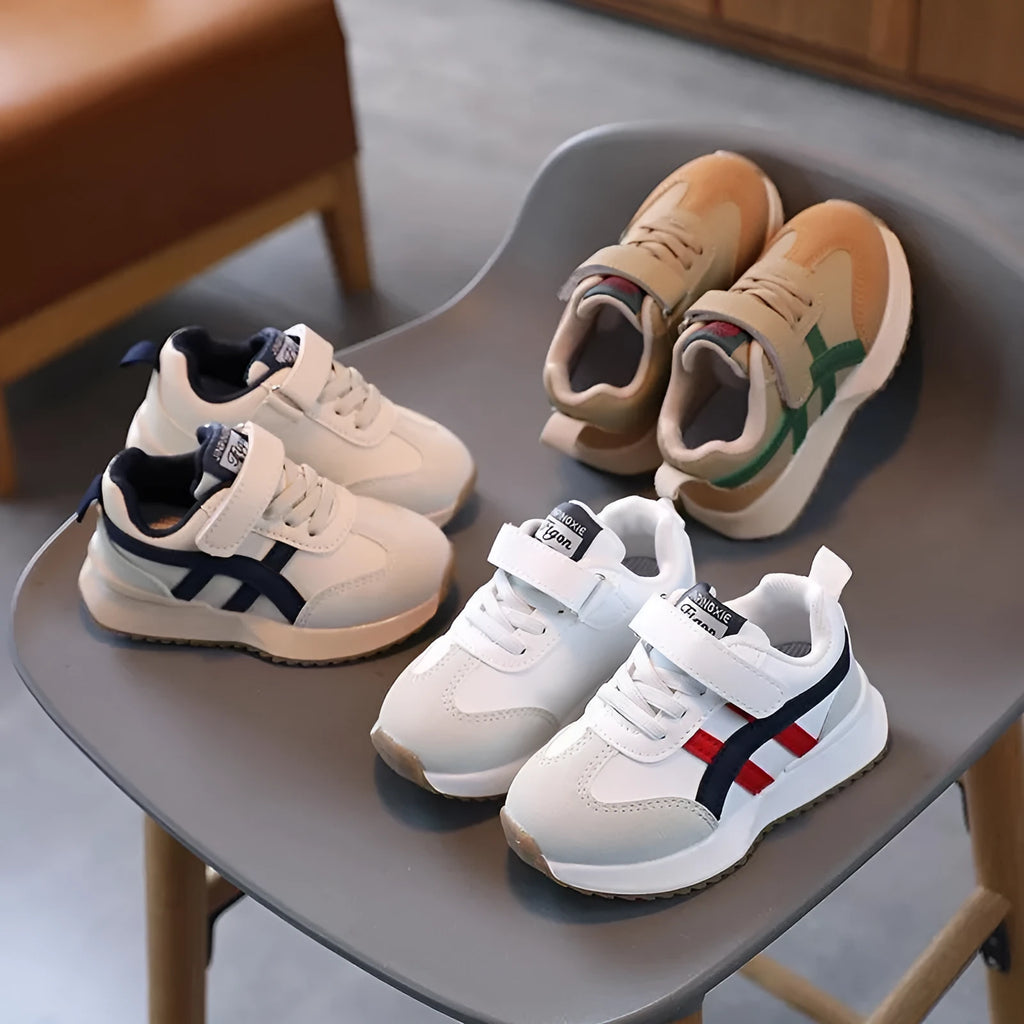 Children's white synthetic leather sneakers with Velcro strap and rubber sole.