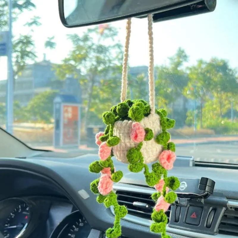 Green and white knitted wool car plant decoration basket with white hanging cord.