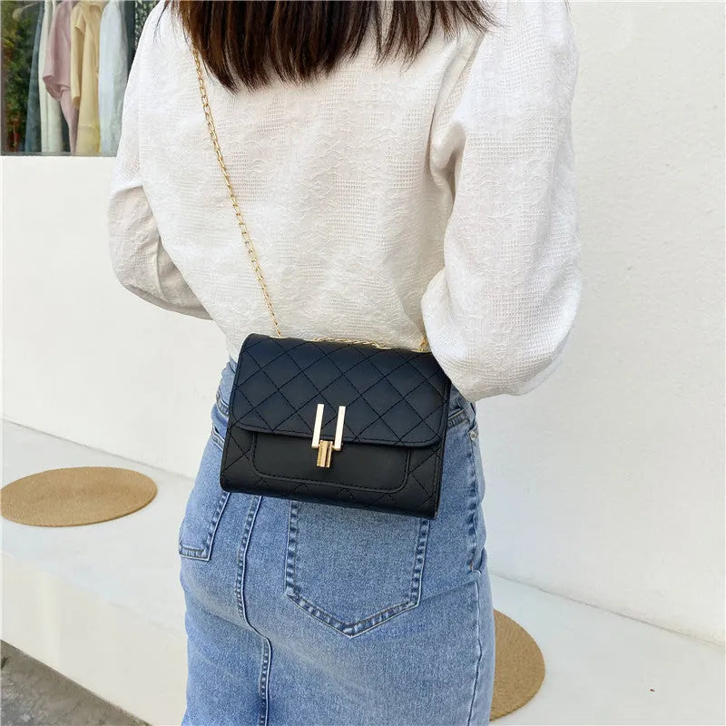 Women's solid colour crossbody bag with diamond lattice chain strap in black, shown from the front.