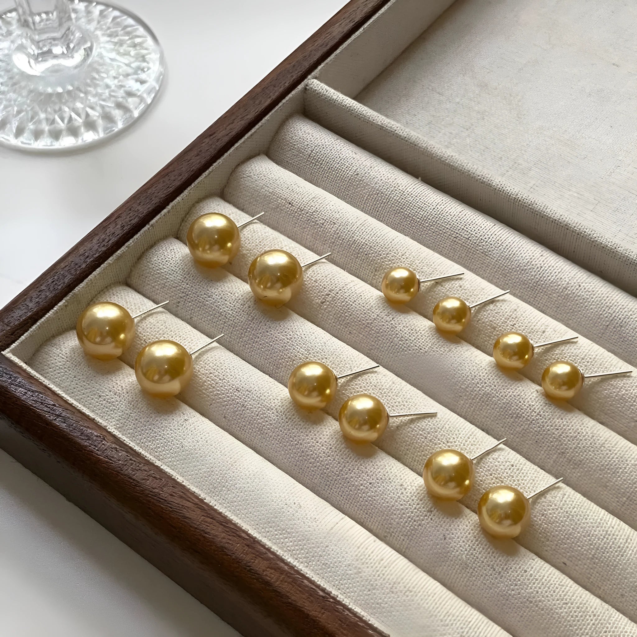 A pair of large geometric pearl stud earrings with an eight-awn star detail on silver settings.