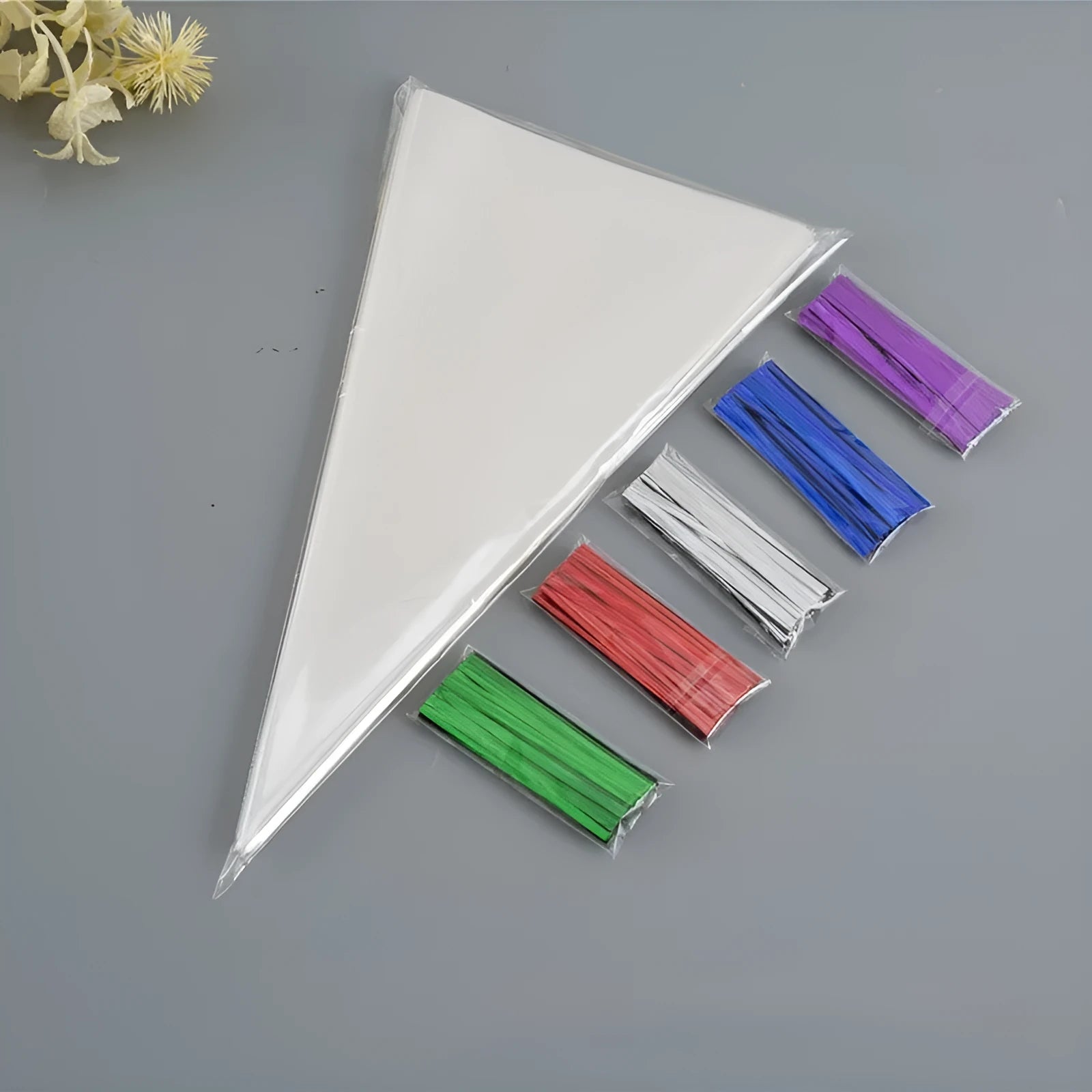Clear triangle-shaped plastic packaging bag with a twisted wire tie closure.