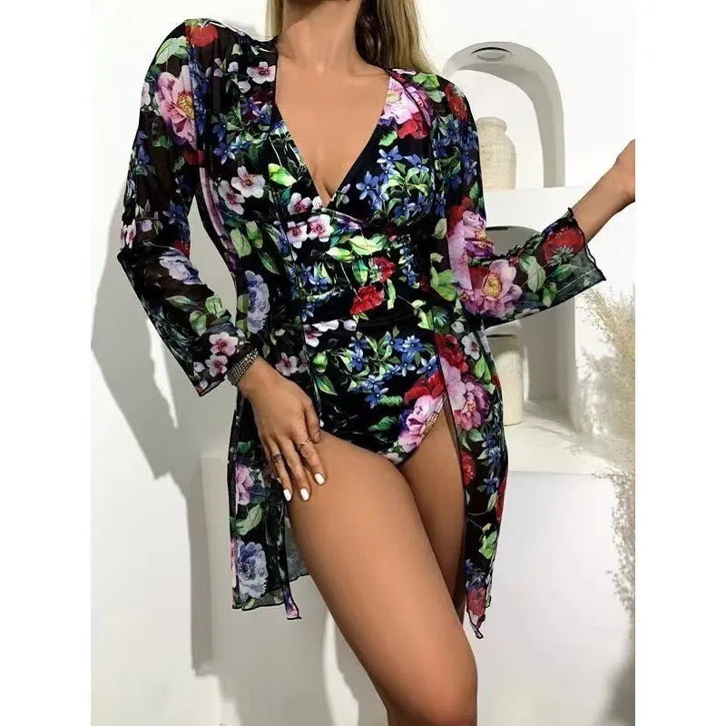Women's floral patterned bikini three-piece set with a matching coat on a hanger