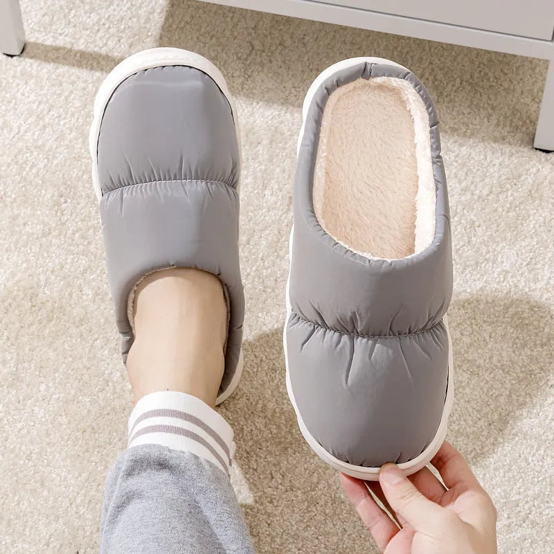 Blue winter indoor slippers with thick rubber sole and plush lining, shown on a hard floor.