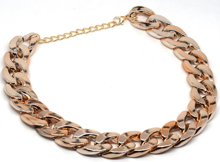 Geometric shaped gold colour dog collar with chain links and buckle on a white background.