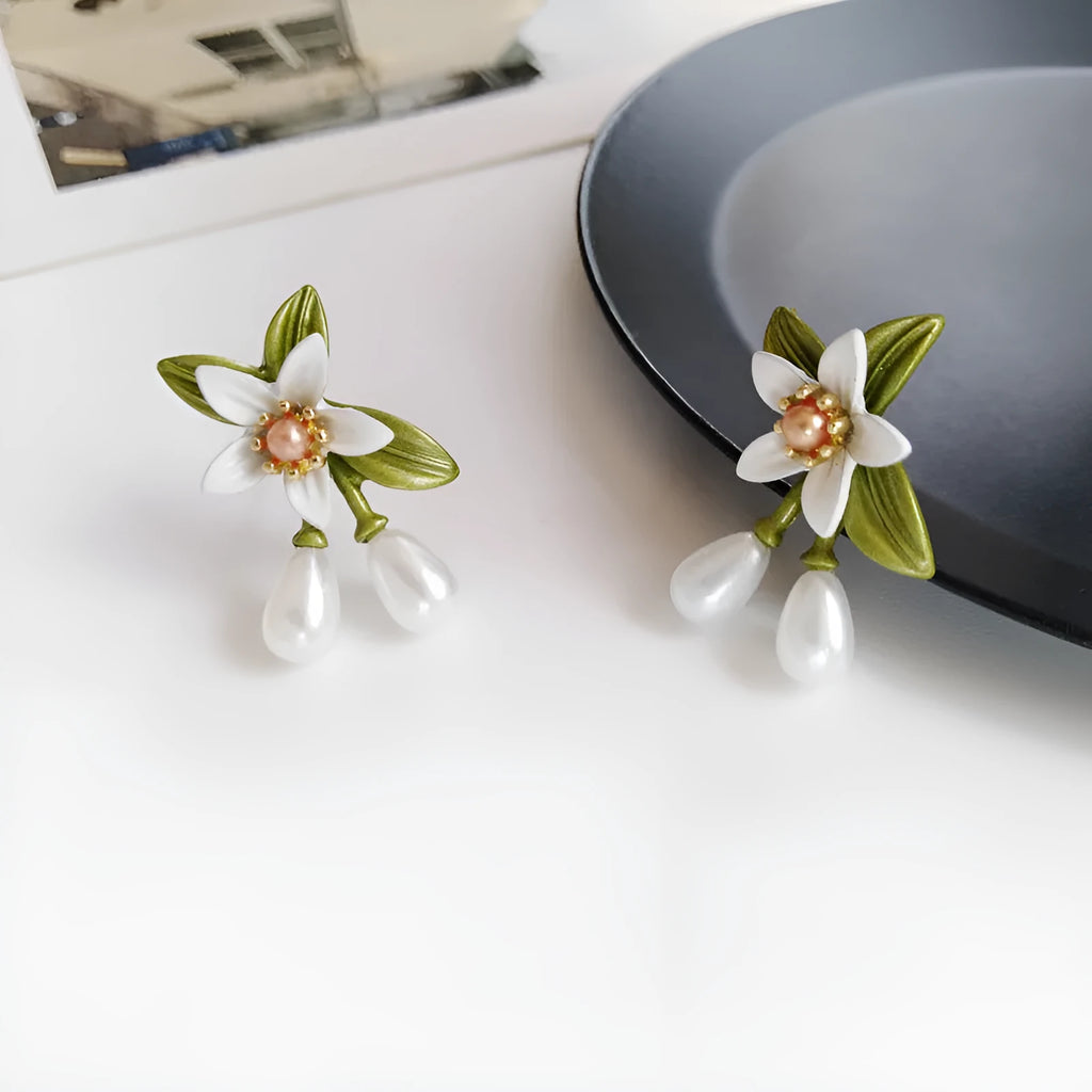 A pair of women's alloy flower earrings shown in two style options: sterling silver needle flowers and a coloured flower clip.
