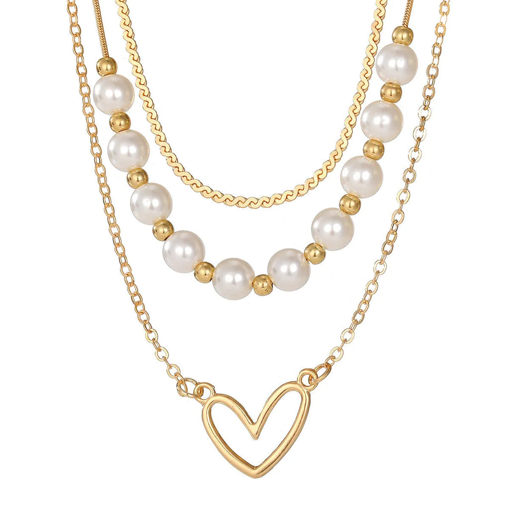 Vintage gold necklace with double heart pendant on textured pearl chain