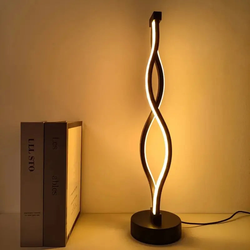 Black aluminium desk lamp with touch and button dimming controls on a desk.