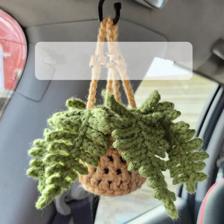 Green and white knitted wool car plant decoration basket with white hanging cord.