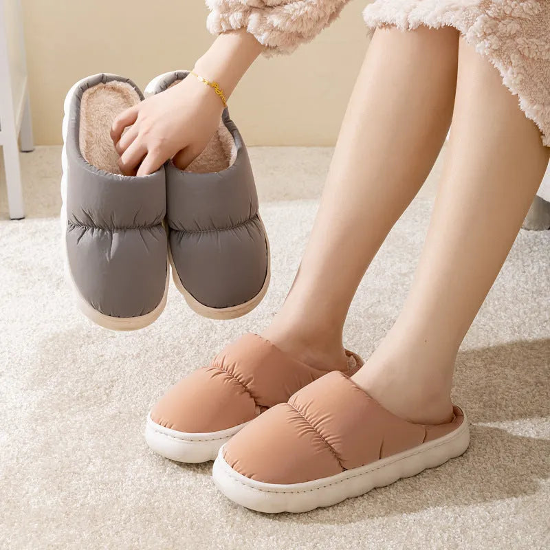 Blue winter indoor slippers with thick rubber sole and plush lining, shown on a hard floor.
