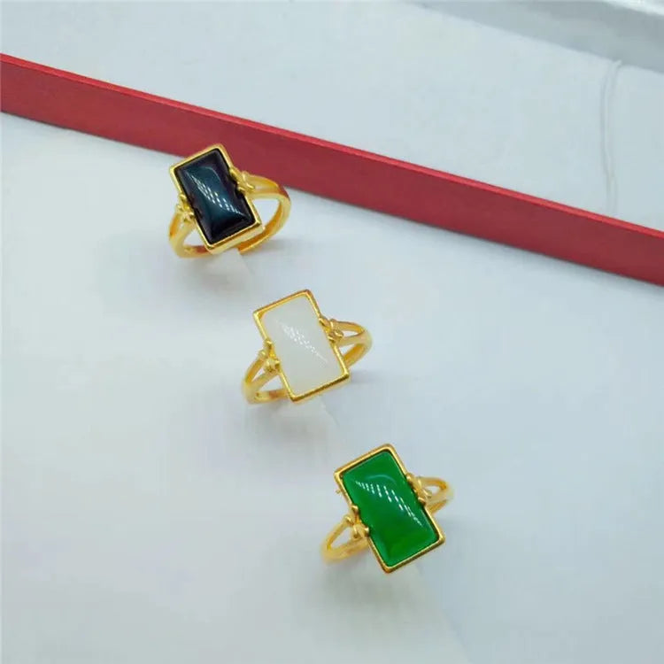 Adjustable brass gold-plated ring with a central electroplated gemstone, shown in black, green, and white colour options.