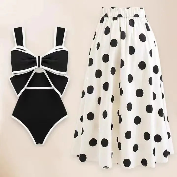Women's black one-piece swimsuit with white round skirt and bow detail on a mannequin