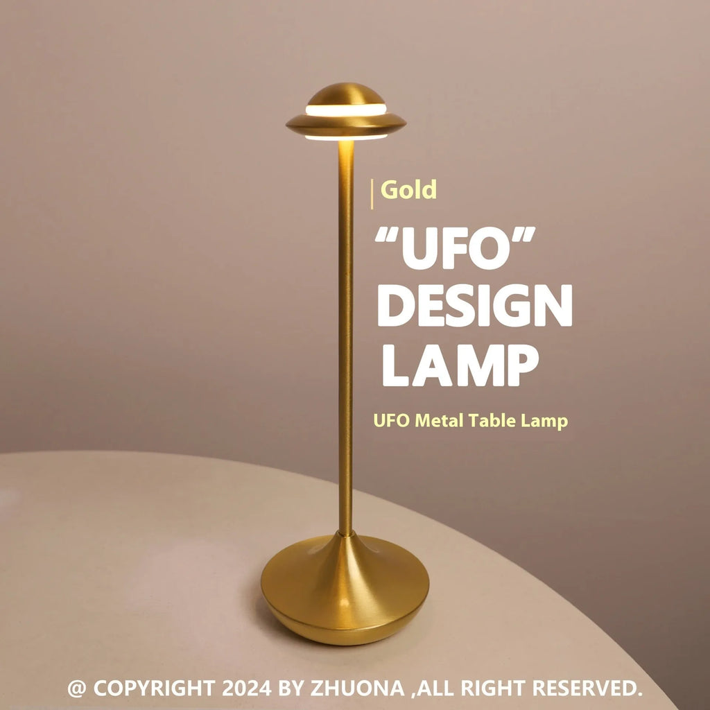 Metallic gold UFO-shaped table lamp with touch dimming on a wooden desk.