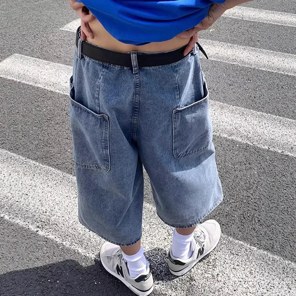 Man wearing blue washed denim pirate shorts with a cropped length and high waist.
