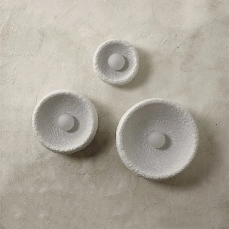 Japanese minimalist wall lamp in resin with warm light, showing three size options