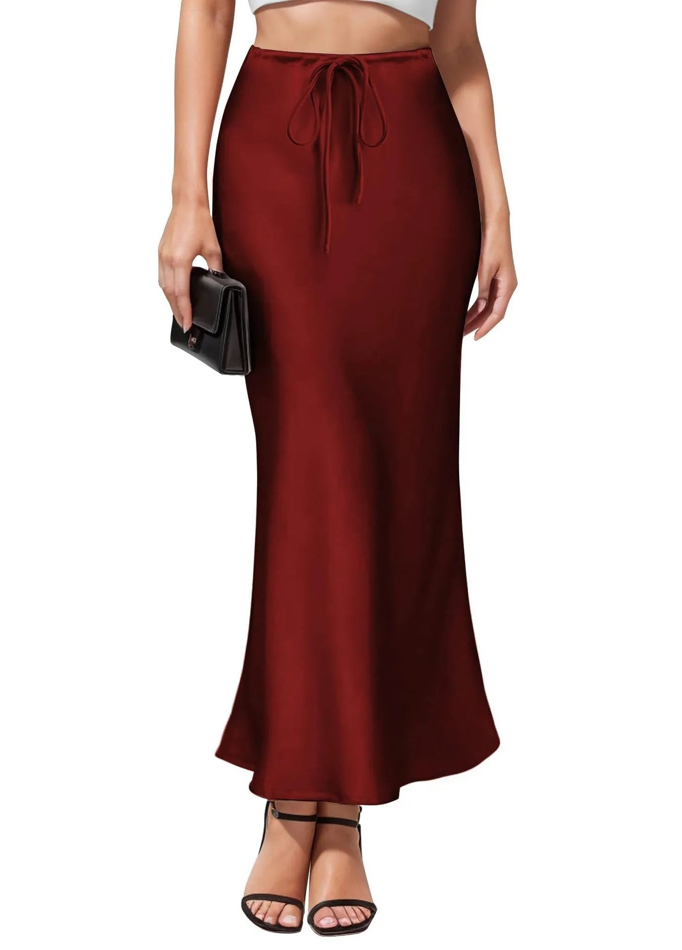 Women's high-waisted asymmetric satin skirt in black on a hanger, showing irregular hem detail.