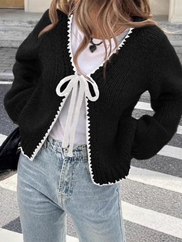 Grey lace-up front cardigan with crocheted flower detail on sleeve, shown loose and open.