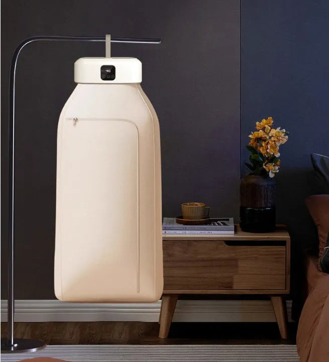 White cylindrical foldable clothes dryer with remote control on flat surface showing compact dimensions