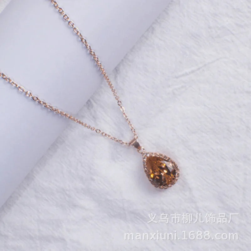 Water drop shaped pendant necklace with geometric design and rhinestone accents in pink colour